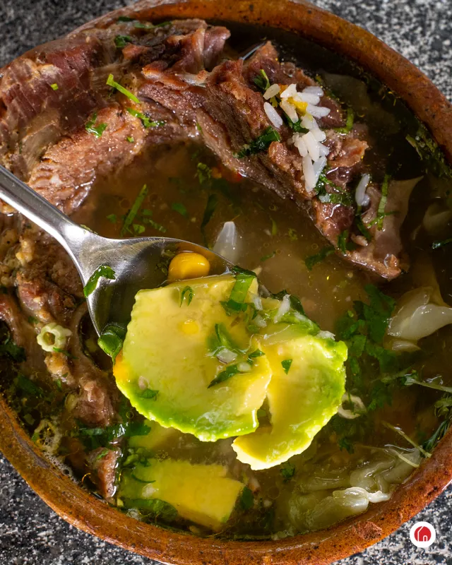 Caldo de res servido en cazuela de barro con verduras