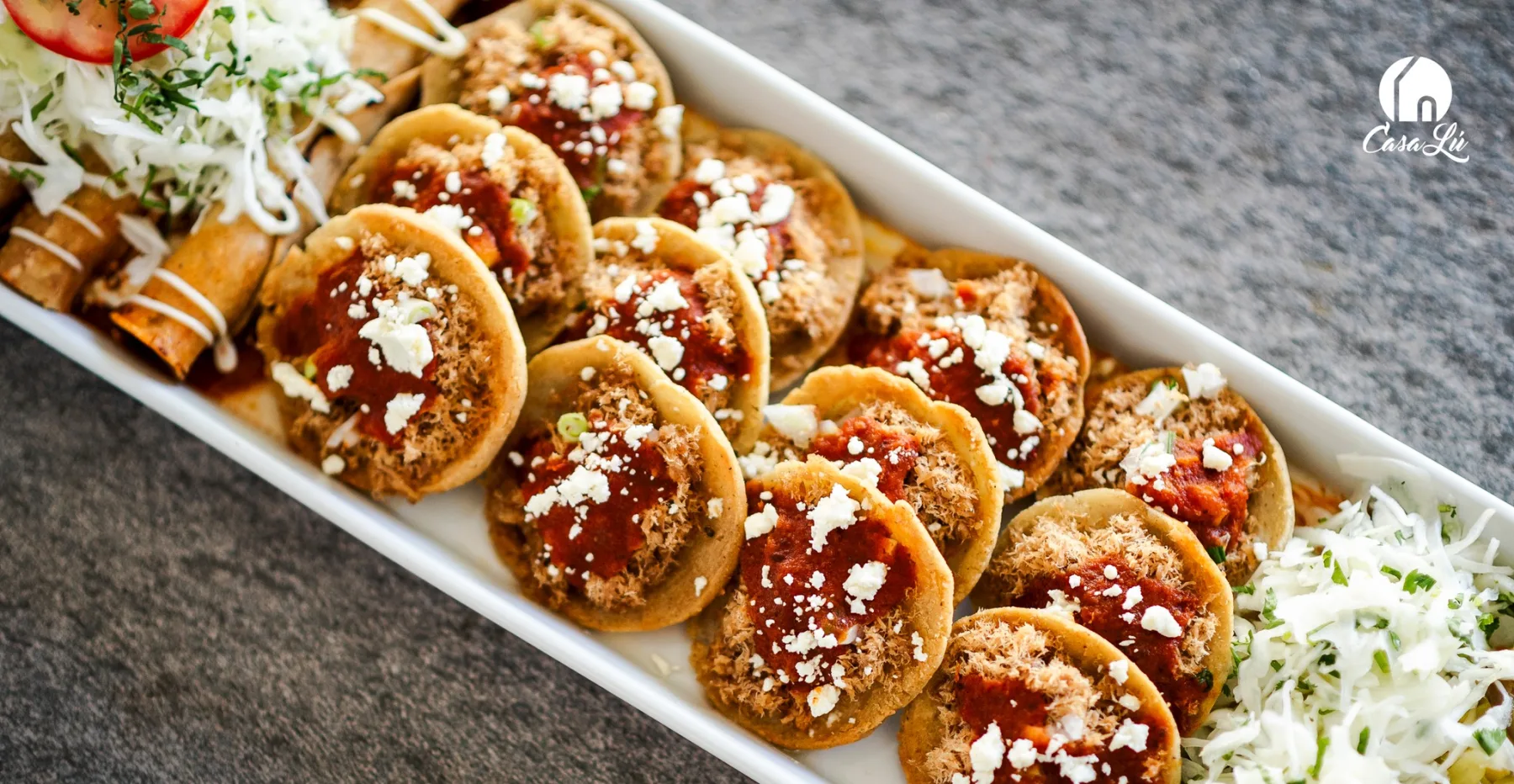 Bandeja de garnachas con carne, salsa de tomate y queso seco, con curtido al lado