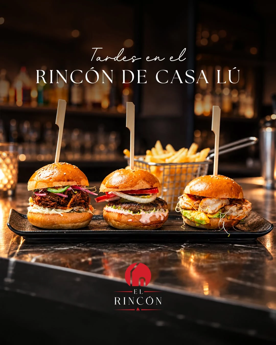 Tres sliders sobre bandeja negra en la barra de El Rincón, con papas fritas atrás