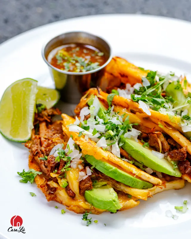 Tacos dorados con aguacate, cilantro y salsa de la casa